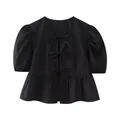 Detail view of a black puff sleeve blouse with three front bow ties and a peplum hem - XS / Black