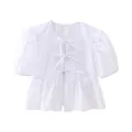 Detailed view of a white puff sleeve blouse featuring elegant front bow tie closures. - XS / White