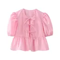 Detailed front view of a pink puff sleeve blouse featuring three stylish bow-tie closures - XS / Pink