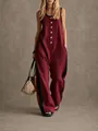 Detail view of burgundy sleeveless wide-leg jumpsuit with gold buttons and black side stripes - Burgundy