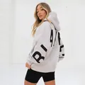 Back view detail of oversized grey hoodie with bold black 'BLAKE' lettering - S / Tops / White