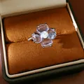 Macro detail of a silver flower ring with four translucent petals in a gift box - Silver-Blue