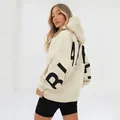 Back view detail of oversized cream hoodie with large black BLAKE lettering - Apricot