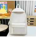 Detail view of a white minimalist backpack in a cozy student study setting - White