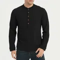 Close-up detail of a men's black long-sleeved Henley shirt with button neckline - S / Tops / Black
