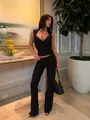 Elegante top a fascia in maglia nera con scollo a V mostrato in un ambiente di lusso. - Taglia S / Top / Nero