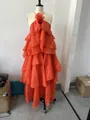 Detail view of an orange tiered ruffle halter dress with a 3D floral chest accent. - XS / Dresses / Long Orange