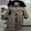 Full view of beige women's thermal ski jumpsuit with black faux fur hood on mannequin - Brown (Tassel Style)