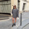 Vista detallada de estilo callejero de un blazer gris oversize con dobladillo único - S / Tops / Gris