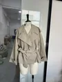 Detailed view of a fashionable short khaki trench coat with a waist belt on a mannequin - S / Tops / Khaki