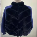 Close-up showing the black faux fur texture and blue knit sleeves of this winter jacket - Blue