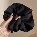 Coletero gigante de satén negro con textura elegante de volantes, vista detallada en la mano - 18cm / Negro