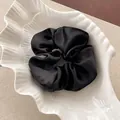 Elegante coletero de satén negro extragrande en un plato blanco con forma de concha de mar - 11cm / Negro