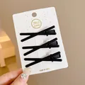 Three black X-shaped matte hair clips displayed on a white branded cardboard card - Cross Twist Duckbill Clip / 3 Pieces (6cm) / Black