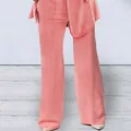 Close-up detail of women's trendy coral pink wide-leg trousers from a stylish two-piece suit set - S / Bottoms / Pink