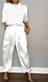 Full view of a model wearing a white satin two-piece set against a gray studio wall - S / Top And Bottom / White