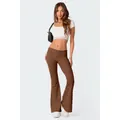 Modella con pantaloni a zampa marroni a vita bassa e set crop top bianco in pizzo - XS / Pantaloni e gonne / Marrone
