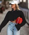 Detail of the cropped long-sleeve black shirt with split cuffs on a street model - S / Tops / Black