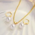 Nahaufnahme von goldener Halskette und Creolen mit großen weißen Perlen für Damen - Polierter Ring Perle Stil / Gold
