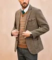 Detail view of a men's British style herringbone suit jacket with a classic pattern. - S / Tops / Camel