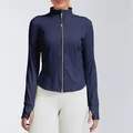 Detail view of a navy blue slim-fit sports yoga jacket with gold zipper and thumb holes - S / Tops / Navy Blue