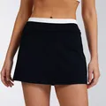 Close-up view of a high-waisted color-block ribbed tennis skirt for women fitness sports - S / Bottoms / Black