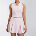 Detail view of women's pink sleeveless zip-up top paired with a pleated tennis skirt - S / Top And Bottom / Light Pink