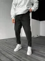 Vue détaillée d'un jean en denim gris foncé pour homme avec des baskets blanches - 34 / Noir