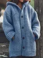Detail van de textuur van een dikke gebreide damesvest met capuchon in blauw - Blauw