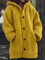 Vista dettagliata di un cardigan giallo lungo con cappuccio e grandi bottoni neri - Taglia S / Top / Giallo
