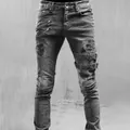 Detailed view of men's distressed biker jeans with decorative zippers and buckles - S / Bottoms / Gray
