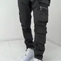 Detailed close-up view of men's black cargo pants featuring multi-pocket design and zippers - S / Bottoms / Black