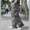 Detalle lateral de pantalones cargo de hombre de talla grande con varios bolsillos - Verde