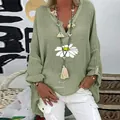 Detail view of a sage green V-neck linen shirt featuring a large daisy floral print - M / Tops / Green
