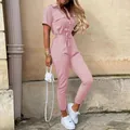 Detail view of pink short sleeve cargo jumpsuit with lapel collar and adjustable waist belt - Pink