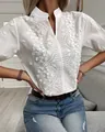 Detail view of white stand collar blouse with intricate floral embroidery and V-neckline - S / Tops / White