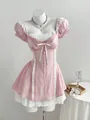 Elegante mini abito rosa con fiocco e maniche a sbuffo in pizzo a contrasto. - Taglia S / Top E Pantaloni / Rosa