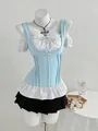 Detalle del elegante chaleco de corsé azul claro con lazo y blusa blanca con volantes - S / Tops / Azul Claro