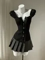 Detailed shot of a black bubble sleeve blouse with pleated ruffles and decorative buttons - XS / Tops / Black