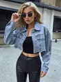 Detail view of cropped denim jacket featuring distressed raw hem and ripped sleeve accents - XS / Tops / Vintage Eco-friendly Blue