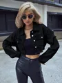 Close-up detail of women's black cropped denim jacket with distressed sleeve accents - XS / Tops / Black