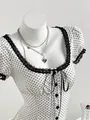 Close-up detail of square neck polka dot blouse with black lace trim and ribbon tie - S / Tops / Apricot