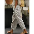 Detail side view of a woman walking in loose-fitting beige cotton linen cropped pants - S / Bottoms / Silver Gray