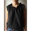 Close-up of black sleeveless cotton linen top with ruffled collar and tie hem detail - S / Tops / Black
