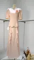 Detail of an elegant pink peplum maxi dress featuring a beaded neckline and ruffles - XS / Top And Bottom / Pink