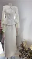 Elegant white tweed two-piece suit with lace collar and pearl buttons on mannequin. - XS / Top And Bottom / Apricot