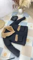 Detail of black winter coat featuring a plush tan fur collar and pocket accents. - XS / Tops / Black