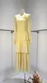 Elegant yellow long-sleeved tiered dress featuring a floral brooch and pleated details - XS / Tops / Light Yellow