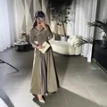 Vollansicht eines eleganten plissierten Abendkleides in einem modernen Wohnambiente - XS / Oberteil Und Unterteil / Armeegrün