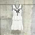 Elegante conjunto de encaje blanco de dos piezas con ribete negro y camelia en maniquí. - S / Top Y Pantalón / Blanco
